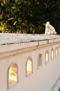 Small decorative elephant sculpture on a white wall next to a park at golden hour, Chiang Mai, Thailand 2023