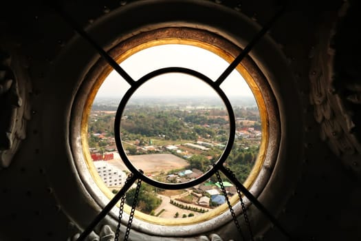 View through a window from the highest floor, top floor inside the head of the Guan Yin Statue onto the surrounding landscape, Wat Huay Pla Kang Temple Complex, Chiang Rai, Thailand 2023