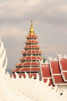 View onto the Phop Chok Dhamma Chedi and the Wat Huay Pla Kang Temple, with the body of a white thai dragon, phaya naga in the foreground, Chiang Rai, Thailand 2023