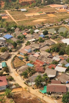 View from the Guan Yin Statue onto a neighborhood of a traditional, rural village right next to it, Wat Huay Pla Kang Temple Complex, Chiang Rai, Thailand 2023