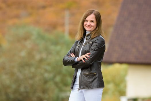 Portrait of a young beautiful girl in casual clothes against the background of a blurred autumn forest