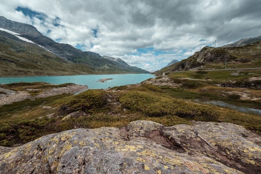 Scenic view on the turquoise colored Lago Bianco lake near the Bernina Pass in the Swiss Alps with dramatic sky