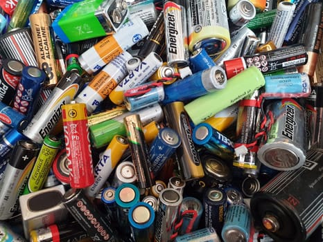Lots of different types of batteries in varying colors - AAA, AA, C, D Nine-volt and others