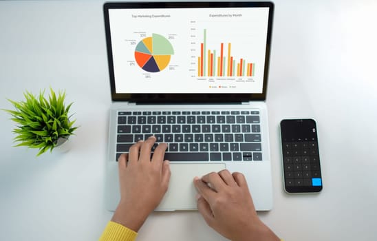 Top view of business financing accounting banking concept. Woman hand doing finances and calculate on desk about cost at home office. Woman working on desk with using app in smartphone and laptop.