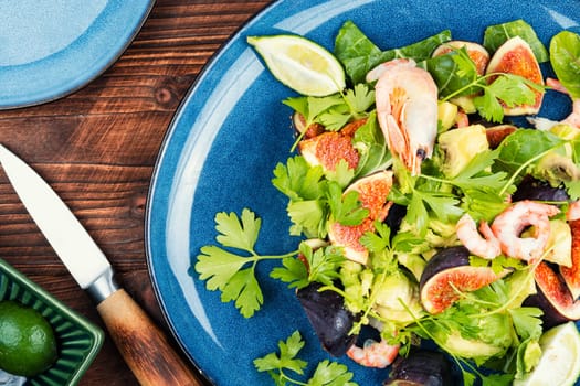 Platter of green salad with figs and figs. Seafood salad.