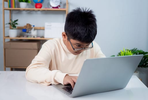 Educational of tech concept, Staying at home, Little Asian boy student using computer laptop learning, Presenting a modern educational way of life, Virtual internet online class from school teacher.
