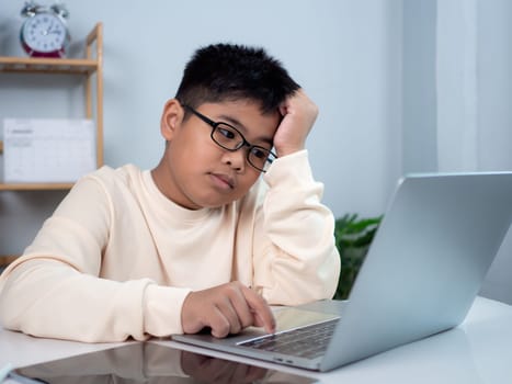 Boy using computer for learning and stressed about online learning, Virtual internet online class from school teacher by remote meeting, Homeschooling and education concept, online education concept.