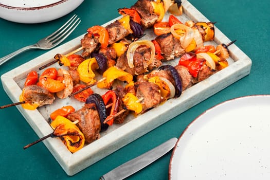 Stick BBQ grilling a variety of meats and vegetables on long thin bamboo skewers.
