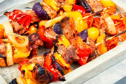 Stick BBQ grilling a variety of meats and vegetables on long thin bamboo skewers.
