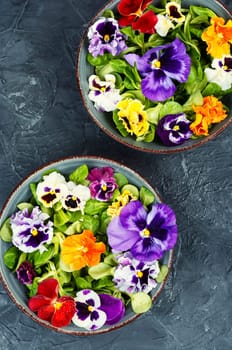 Plate of healthy summer salad with fresh ingredients and edible flowers. Clean eating concept.