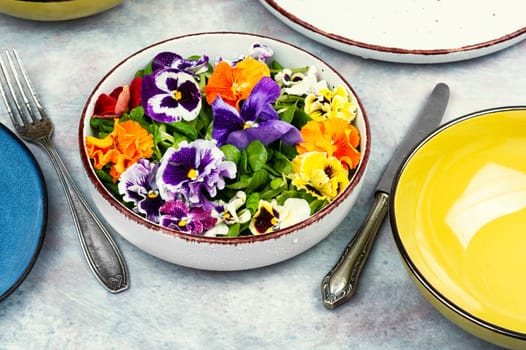 Plate of healthy summer salad with fresh ingredients and edible flowers. Clean eating concept.