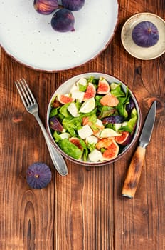 Vitamin salad with figs, greens and cheese. Close up.