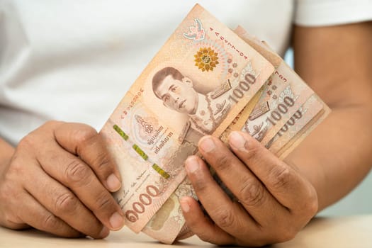 Asian woman counting Thai baht banknote money, investment economy, accounting business and banking.