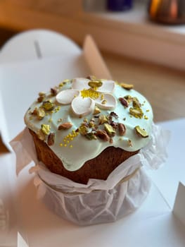 Beautifully decorated cake on a table, adorned with green icing and sprinkled with nuts and meringue pieces. Pastry is wrapped elegantly, perfect treat for special holidays. Sweet food and delicious vegan concept.