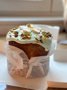 Beautifully decorated cake on a table, adorned with green icing and sprinkled with nuts and meringue pieces. Pastry is wrapped elegantly, perfect treat for special holidays. Sweet food and delicious vegan concept.