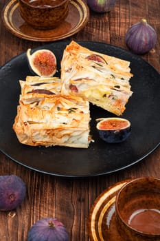 Figs pie with fila dough and figs on a plate on the table. Fall fruit dessert recipe.