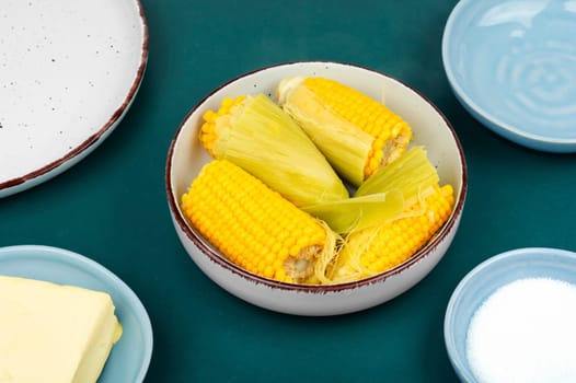 Appetizing sweet boiled corn on wooden background. Flavored boiled corn.