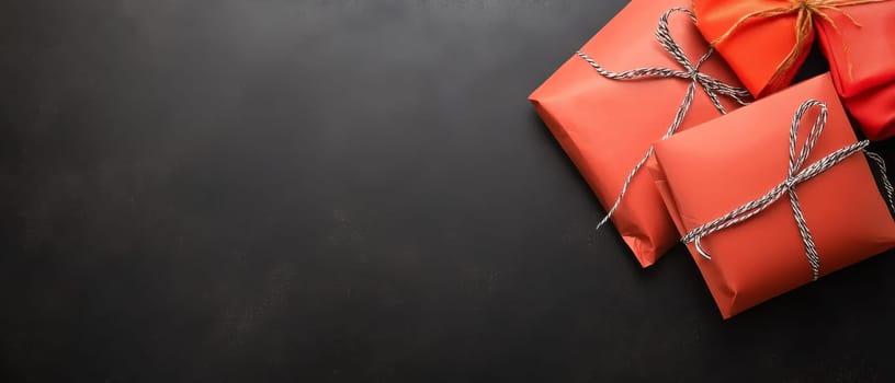 Red gift boxes tied with twine on a black background, featuring generous copy space for text placement.