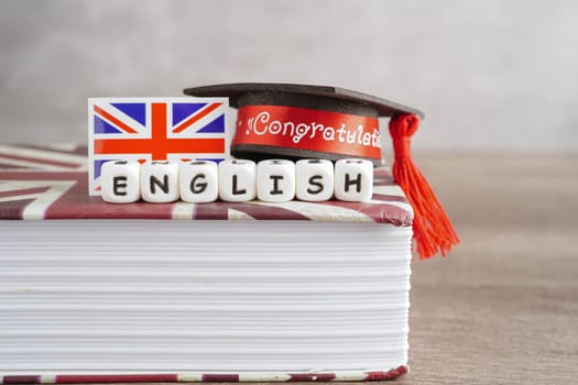 English book with graduate hat, learning and tutorial for foreigner.