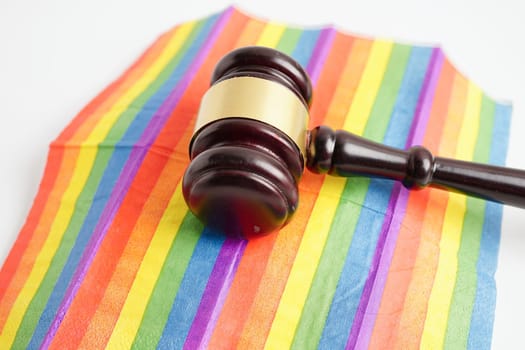 Gavel for judge lawyer on rainbow flag, symbol of LGBT pride month.