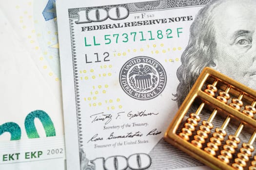 Gold abacus on banknote money, finance trading investment business currency concept.