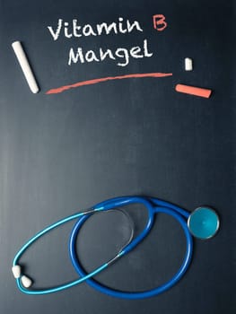 Blackboard with the German words Vitamin B deficiency and a stethoscope, medical or health care concept