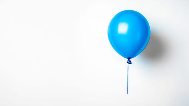 Bright blue balloon floats gracefully against a clean white wall, offering space for text or design elements