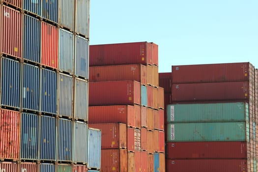 Stacked variegated shipping containers of tex, DONG FANG and other freight ship companies at the Port of Hamburg