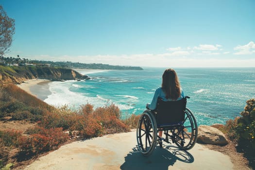 A woman in a wheelchair enjoys the breathtaking view of cliffs and ocean under a clear blue sky, feeling inspired.