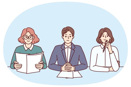 Business people from recruiting company with skeptical expression are conducting interview sitting at table in office. Man and two women work as HR managers and participate in recruiting processes