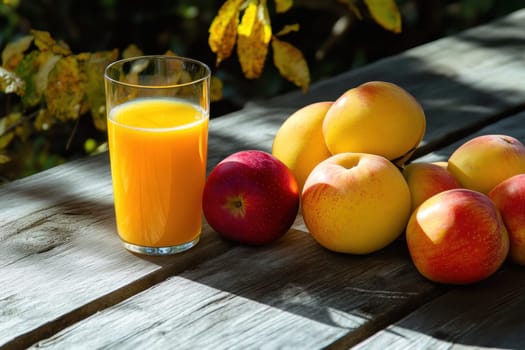 A glass of orange juice sits beside a collection of vibrant apples on a rustic wooden surface during a sunny day.