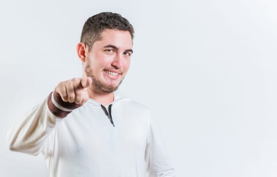Attractive cool guy pointing at the camera isolated. Happy teenage guy pointing at you on isolated background
