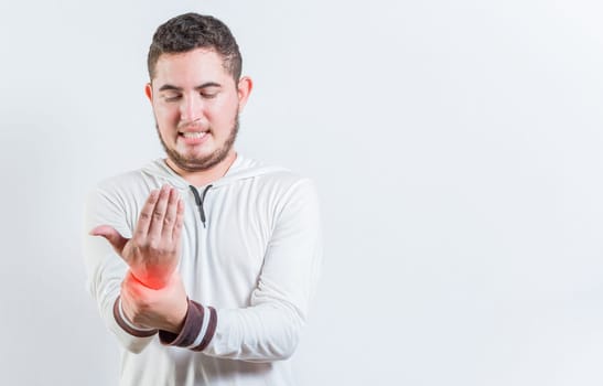 Person with arthritis pain rubbing hand isolated. Suffering young man with pain in hand joints isolated
