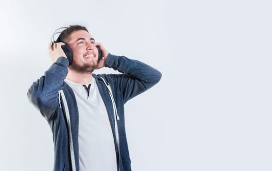 Guy enjoying music holding headphones isolated. Happy person listening to music holding headphone isolated