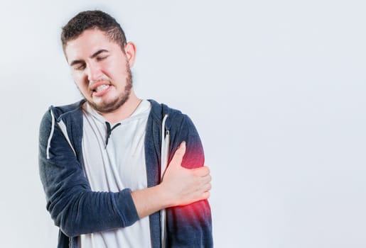 Unhappy man with arms muscle pain isolated. Sore young man with arms pain isolated