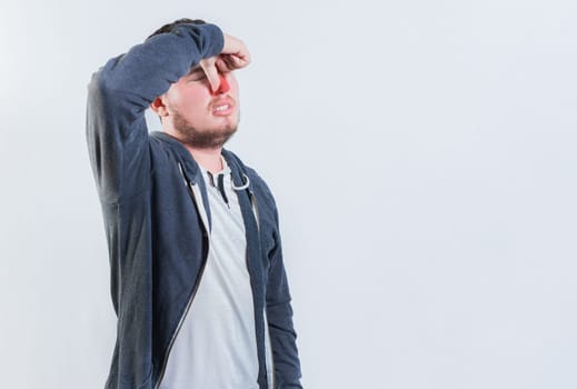 Suffering man with nasal bridge pain isolated. Guy suffering with nasal bridge on isolated background