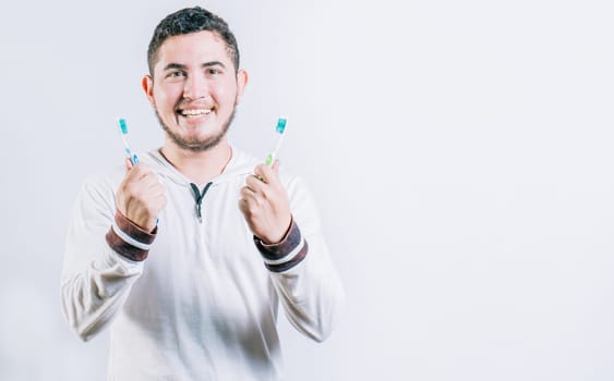 Teenager holding two toothbrushes isolated. Oral health concept. Toothbrush change concept