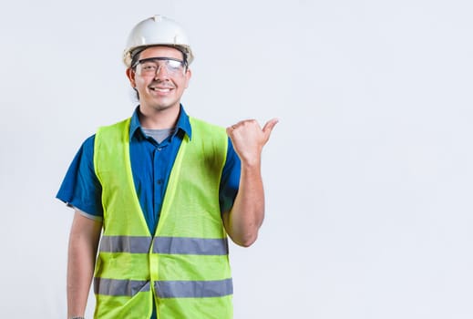 Portrait of engineer man pointing to side isolated. Smiling engineer man pointing side isolated
