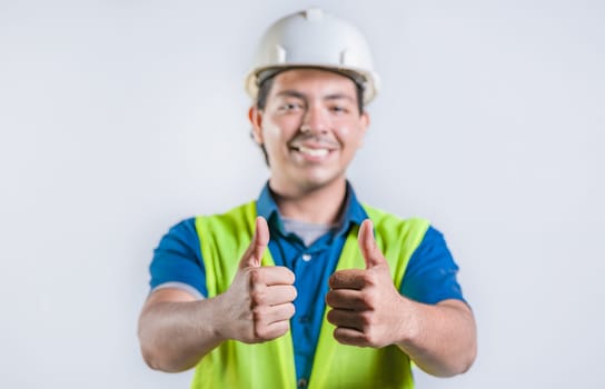 Smiling latin engineer geesturing ok isolated. Positive male engineer with thumbs up, isolated