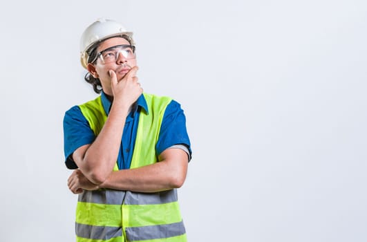Pensive builder man with hand on chin isolated. Young builder wondering looking up with hand on chin
