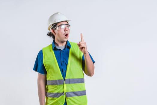 Amazed engineer pointing up isolated. Surprised young architect pointing up. Engineer with astonished face pointing at blank space