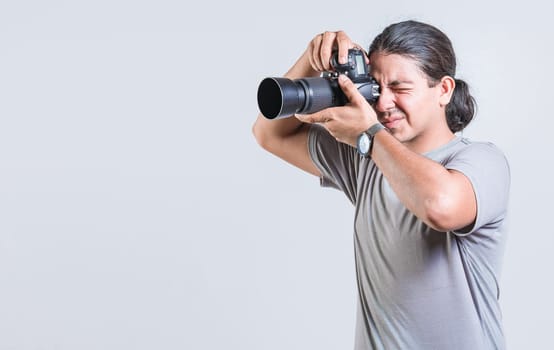 Male photographer taking photos isolated. Handsome photographer taking photos with dslr camera isolated