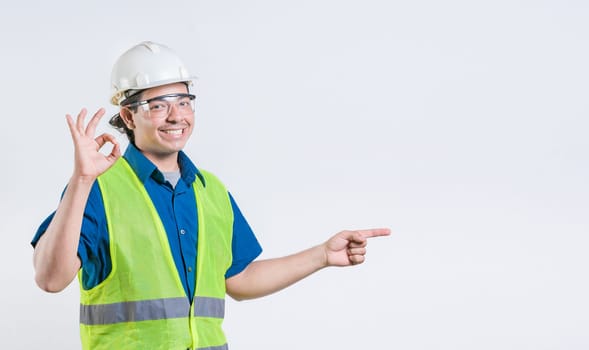 Portrait of latin engineer recommending and pointing aside. Cheerful engineer pointing at promotion isolated