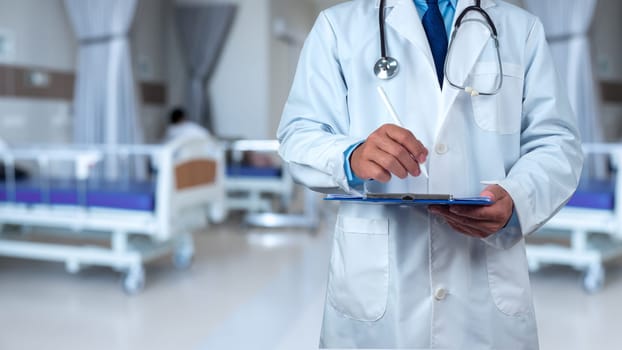 Doctor with stethoscope in white coat holding clipboard standing on the background inside a hospital, Writing medical record diagnosis, Close up, Healthcare and medicine, Concept of treating disease.