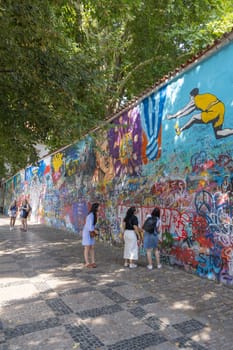 Prague, Czech Republic - September 3, 2024: Lennon Wall, colorful mural covered with graffiti inspired by John Lennon and fragments of Beatles song lyrics. It is a symbol of ideals like love and peace