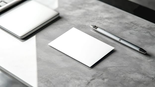 Blank business card is laying on a desk with a pen and laptop beside it, waiting for a designer to add a logo and brand