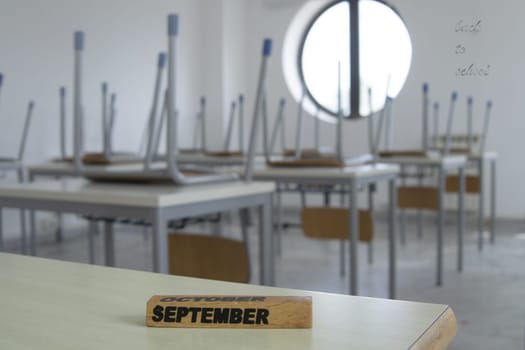 empty school classroom with the word september on the chair