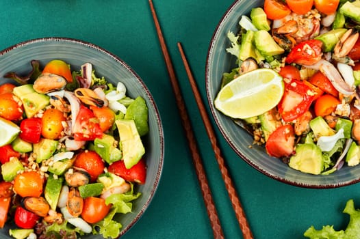 Seafood salad with shrimp, octopus, mussels, tomatoes, avocado and mixed greens. Healthy food. Flat lay with copy space