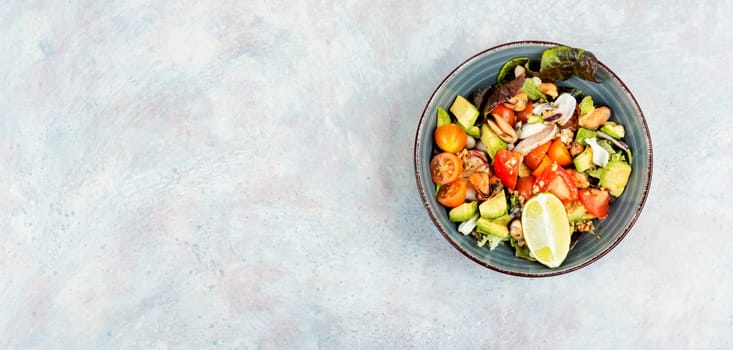 Seafood salad with shrimp, octopus, mussels, tomatoes, avocado and mixed greens. Healthy food. Flat lay with copy space