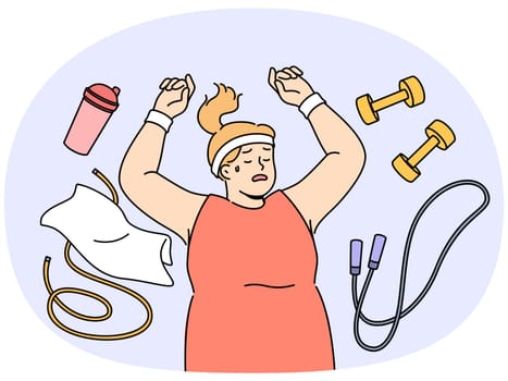 Fat woman lies on floor among fitness accessories, falling asleep after workout and dreaming of getting rid of overweight. Lazy girl does not want to go in for sports and fight overweight